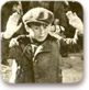 ילד מרים ידיים בעת הוצאת יהודים מהבונקרים בזמן הכנעת המרד בוורשה, 1943