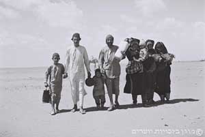 משפחה תימנית הולכת במדבר לעבר מחנה המעבר שהקים ארגון הג'וינט ליד עדן, נובמבר 1949